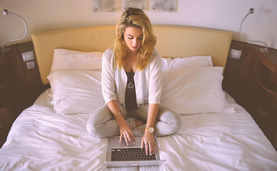 Photo of woman shopping online from bed
